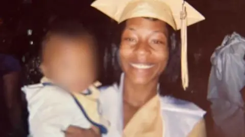 Handout image of Sonya Massey wearing a graduation cap. She carries a child, whose face has been blurred 