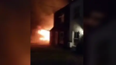 Submitted Orange flames coming out the left of a house. 
