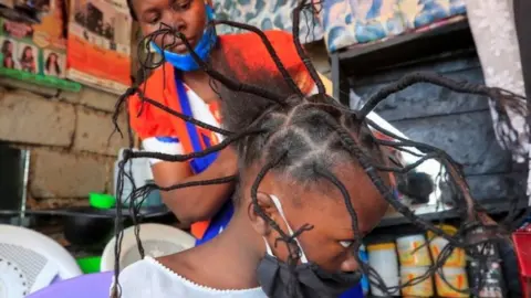 A child has her hair threaded in a salon in Kenya's capital, Nairobi, on 29 April.