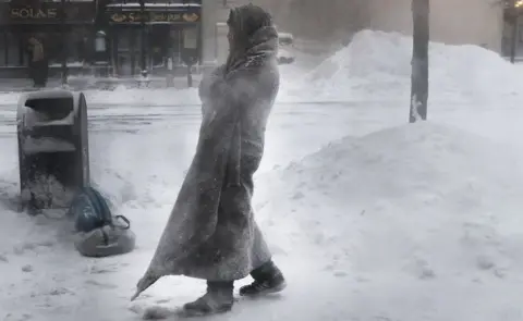 Getty Images A homeless man on the streets of Boston as snow falls from a massive winter storm, 4 January 2018