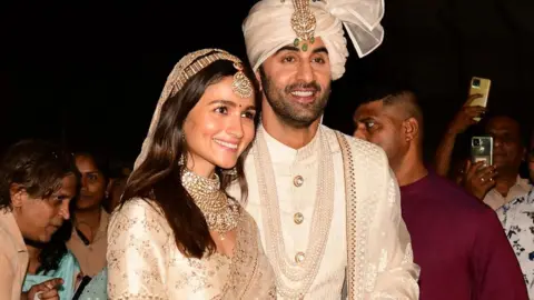 Getty Images Bollywood actors Ranbir Kapoor (R) and Alia Bhatt pose for pictures during their wedding ceremony in Mumbai on April 14, 2022.