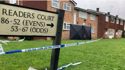 Lewis Adams/BBC Road sign of Readers Court with a police cordon.