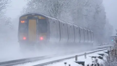 PA Media A South-eastern train makes its way through Ashford in Kent as rail services remain disrupted in the icy weather