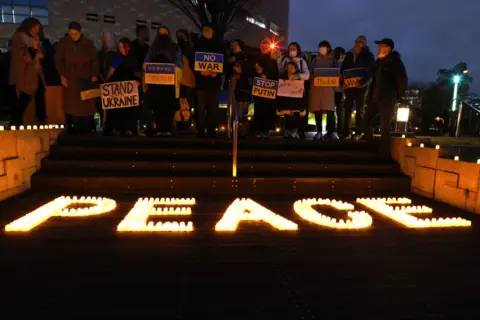 Buddhika Weerasinghe/Getty Images Ukrainians living in Japan hold anti-war placards and take part in the candlelight vigil for peace at the the Osaka Museum of History site on February 24, 2023 in Osaka, Japan.