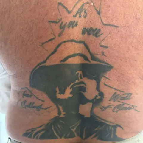 John Smallbones/PA Media A black and white tattoo of Liam Gallagher which has his name and 'Wall of Glass' written either side of it and As you Were above. It is on John Smallbones' back.