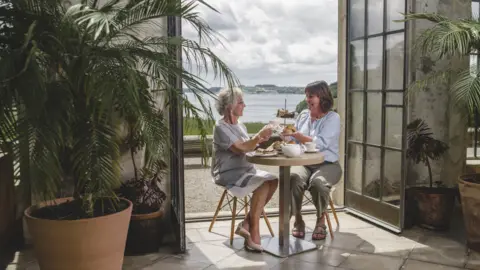 National Trust People enjoying a cream tea at Trelissick House