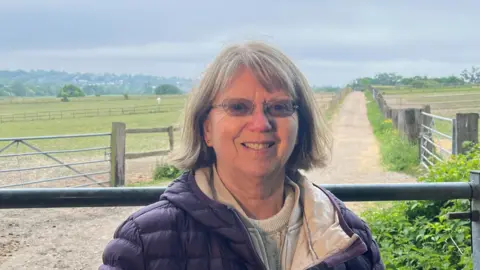 Carol Fisk standing in green belt site Vicarage Farm