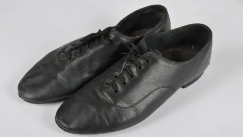 Special Auction Services A pair of black leather shoes. 
