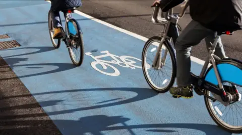 two cyclists on a blue cycling lane