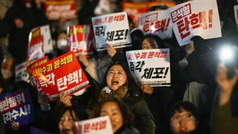 Getty Images People take part in a protest calling for the resignation of South Korea President Yoon Suk Yeol at the National Assembly in Seoul on December 4, 2024.