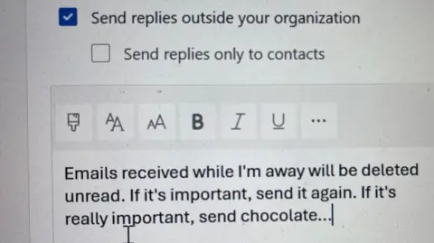 Image of an automatic reply in Outlook. It reads: Emails received while I'm away will be deleted unread. If it's important, send it again. If it's really important, send chocolate