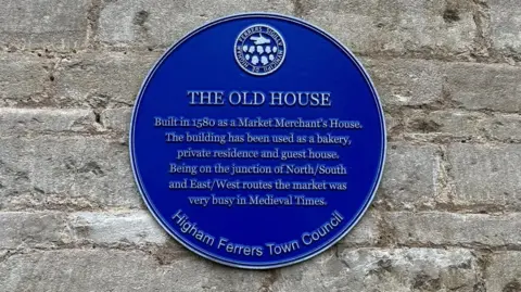 Ollie Conopo/BBC A blue plaque in Higham Ferrers 