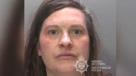 A mugshot of a woman with messy brown hair. She is looking at the camera with a neutral expression.