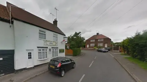 A street view of East Lane in Edwinstowe, Nottinghamshire, outside the Hammer and Wedge pub on the left of the frame. 