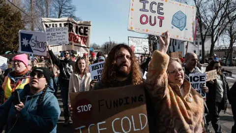 Getty Images protesters hold up signs demanding ICE out of Minnesota