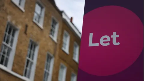 A pink and purple "Let" sign is in the foreground with a yellow brick property in the background.