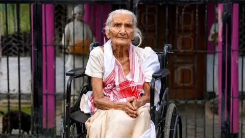 A 97-year-old Lokada Duarah was carried onto a banana tree trunk and taken to safety after floodwaters rose around her home