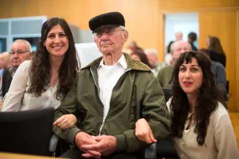 BERND THISSEN//AFP/Getty Images Holocaust survivor Joshua Kaufman (C) is accompanied by his daughters Rachel (L) and Alexandra as he attends a trial against a former Auschwitz guard at the court in Detmold, western Germany, on May 13, 2016.