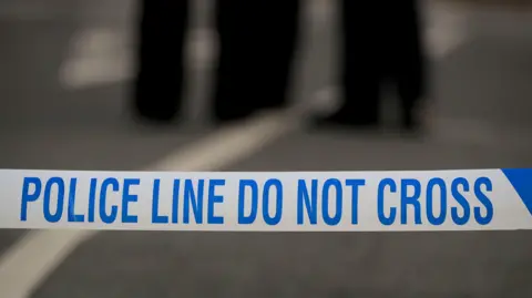 A stock image of blue and white police tape with the words "police line do not cross".