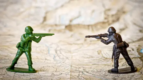 Getty Images Toy soldiers aiming guns at each other