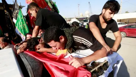 Reuters People react over the coffin of a protester killed during the unrest. Photo: 5 October 2019