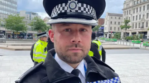 Supt Pearson is wearing a police uniform and cap