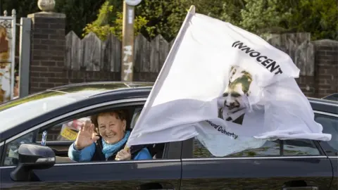 PA Media A cavalcade of cars passed through Ballymurphy on Tuesday evening to thank the community for its support