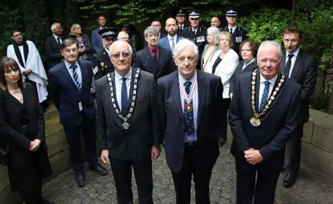 Hertsmere Borough Council Mourners gather at the memorial service to mark 20th anniversary of the Potters Bar rail crash. From left to right, front row, are Cllr John Graham, Deputy Mayor of Hertsmere, Colonel Kevin FitzGerald, Deputy Lord-Lieutenant of Hertfordshire and Chairman of Hertfordshire County Council, Cllr Seamus Quilty