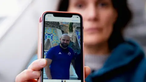  Oihana Goiriena, wife of journalist Pablo Gonzalez, shows a picture of her husband on her phone, April 2023