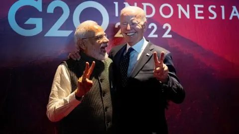 Getty Images President Joe Biden (R) gestures with India's Prime Minister Narendra Modi as the two leaders met in a hallway as Biden was going to a European Commission on the Partnership for Global Infrastructure and Investment on the sidelines of the G20 Summit in Nusa Dua, on the Indonesian island of Bali, on November 15, 2022.