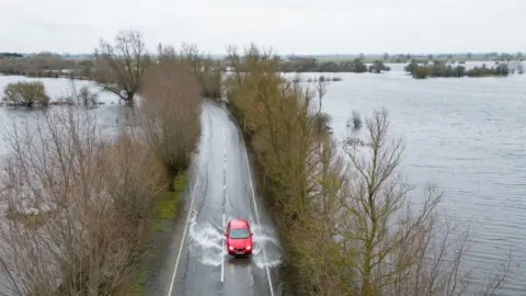 PA Media A car driving on a wet road