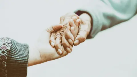 Getty Images Two hands holding each other