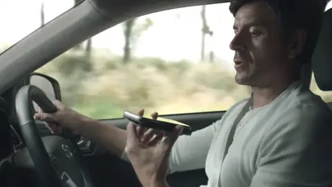 NSW Transport A man using his phone while driving