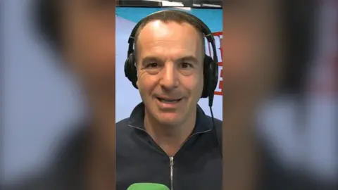 Martin Lewis wearing headphones in a podcast studio