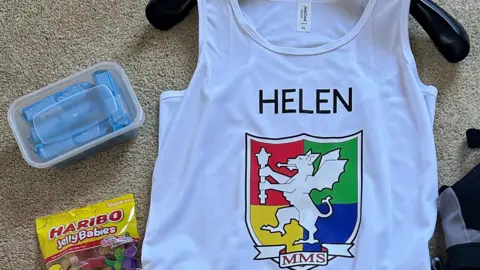 Handout A white running vest with Minehead Middle School's logo is on a hanger with running snacks next to it. 