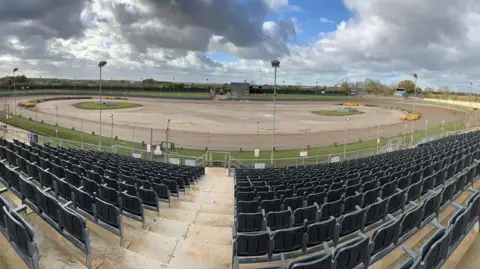 British Speedway Internal view of Northampton Shaleway, showing the track and rows of seating on a bright but cloudy day.