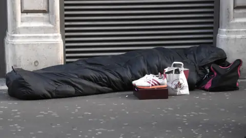BBC Person sleeping on pavement