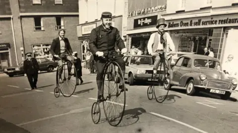 Colin Bedford Three men on vintage bikes in March town centre in 1984