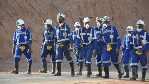 Orano A group of Orano miners in Niger walking, wearing blue boiler suits