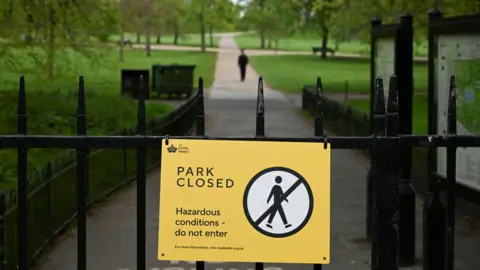 Reuters A yellow sign on a closed gate of the gardens, which says 'park closed'.
