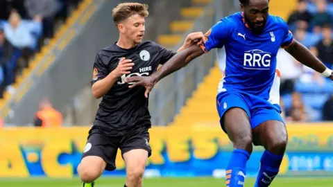 Will McGowan challenges Oldham Athletic's Emmanuel Monthe for the ball during a National League game