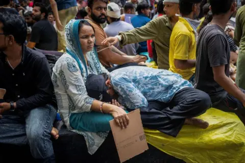 Reuters Krishna Arya, 16, an Injured supporter of India's Cockroach Janta Party (CJP) rests in her mothers lap at a protest site.