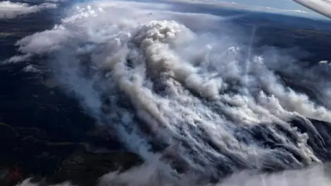 Steve Kenyon Roberts/Deeside Gliding Club The aerial image shows thick smoke rising from a landscape of hills and moorland.
