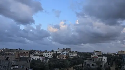 A landscape shot of buildings beneath a cloudy sky