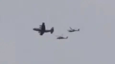 A still of a video showing what appears to be a US plane accompanied by two helicopters flying over southern Iran