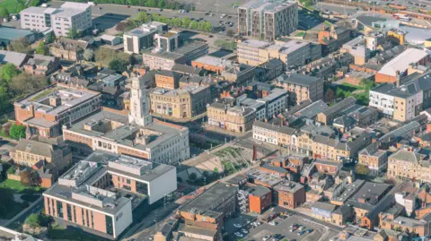 An aerial view of Barnsley, with houses, flats, car parks and roads in view.