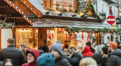 East Riding of Yorkshire Council Crowds are all wrapped up in front of stalls at Beverley's Festival of Christmas.