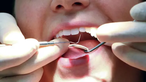 A dentist examining someone's teeth.