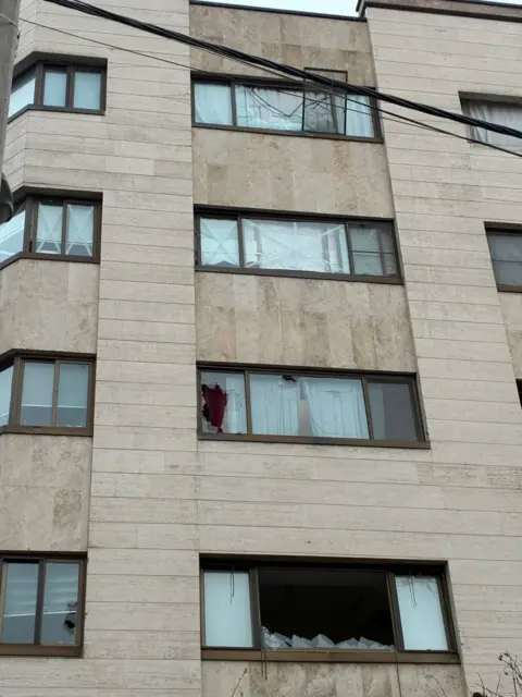 Mamlekate A picture shows windows broken or blown out in a block of flats in Tehran.