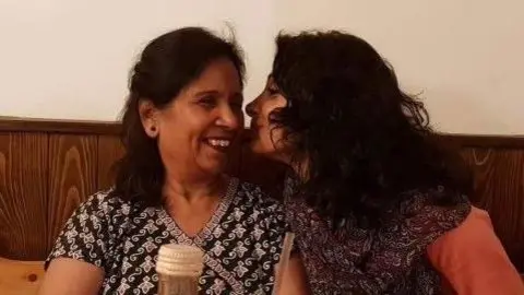 Balvinder Sopal Balvinder Sopal kisses her mother's cheek as they sit at a table together. They are both smiling